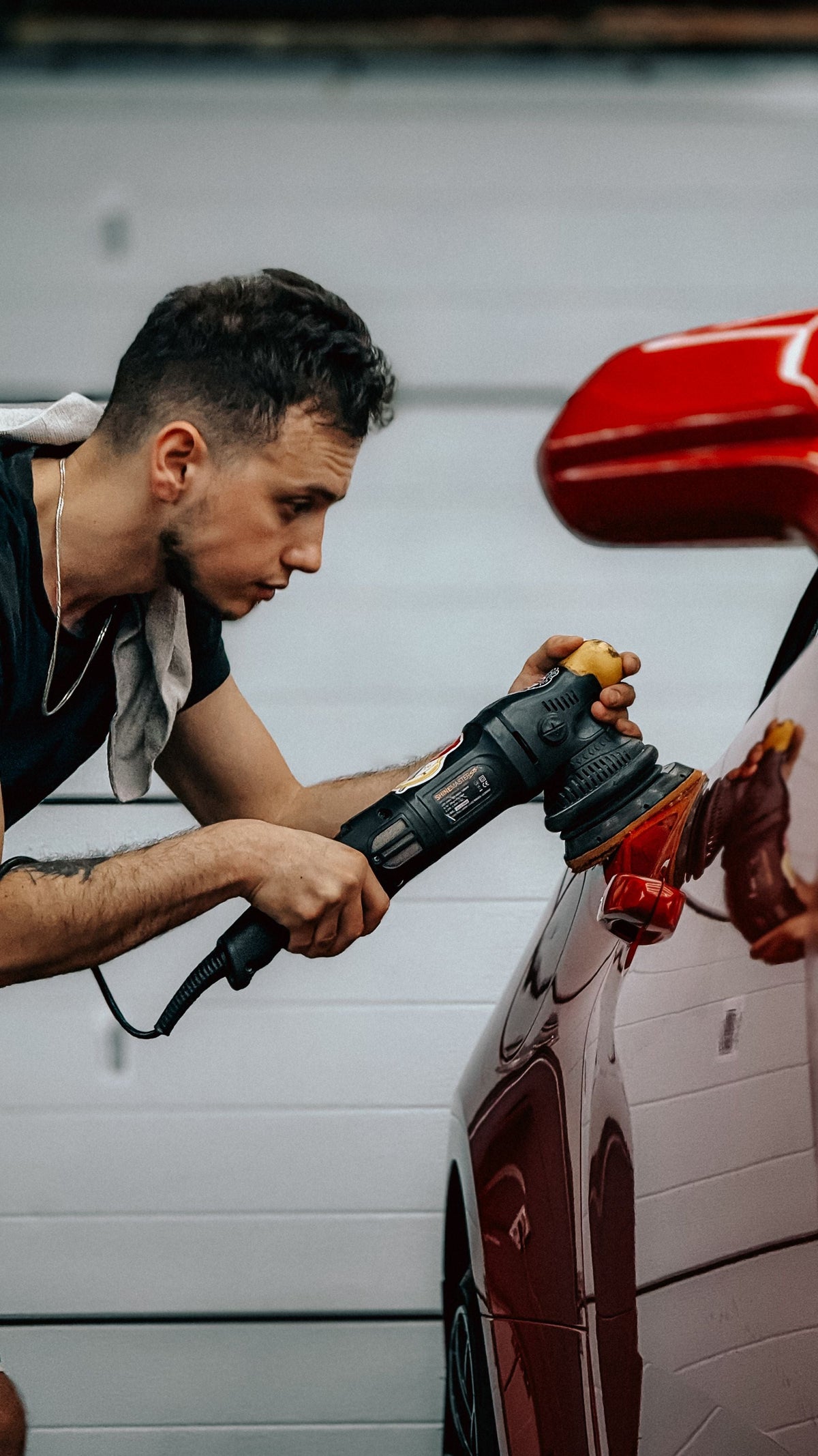 Detailer machine polishing red paintwork during paint correction