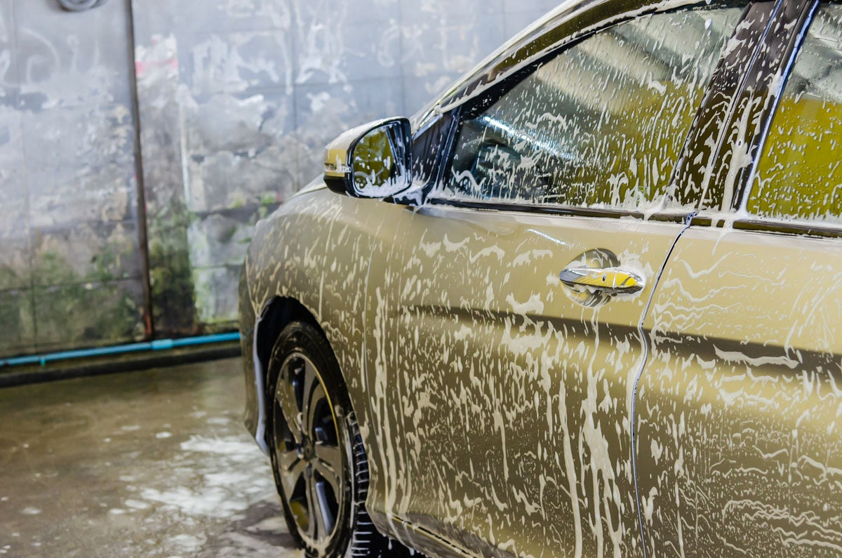 Car covered in soap foam during a hand wash
